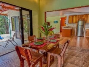 Interior view of dining area with wooden table, chairs, and sliding door to patio.