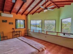 Spacious bedroom with large windows and colorful walls near Dominical.