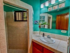 Interior view of a bathroom with a sink, mirror, and tropical decor in Costa Rica.