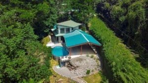 Aerial view of a house with a saltwater pool and lush greenery in Dominical.