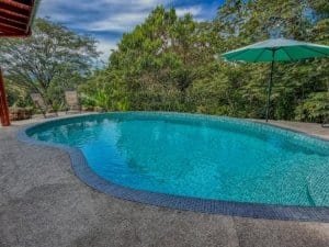 Beautiful saltwater pool with lush greenery and outdoor seating in Dominical.