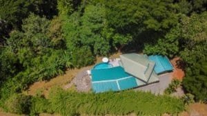 Aerial view of a property with blue roofs and lush greenery near Dominical.