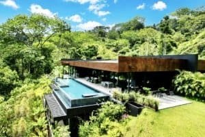 Modern luxury home with infinity pool overlooking lush green forest in Costa Rica.