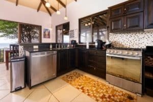 Spacious kitchen with dark wood cabinets and ocean view windows in Dominical.