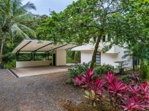 Modern rainforest home with pool, surrounded by lush tropical plants in Dominical.