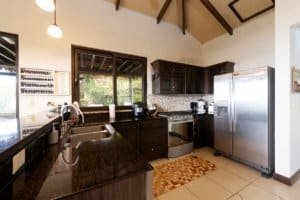 Costa Rican kitchen with dark cabinets, stainless steel appliances, and large window.