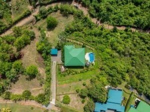 Aerial view of a luxury home with infinity pool and manicured garden in Dominical.