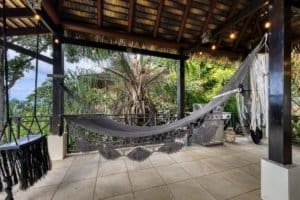Relaxing hammock on tropical veranda with lush garden view in Dominical.