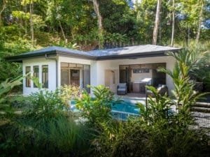 Contemporary Costa Rican home with pool surrounded by lush greenery and trees.