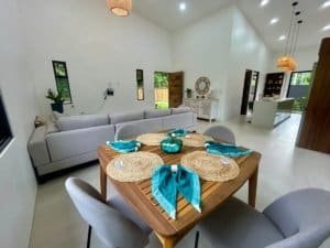 Bright living and dining area of a modern tropical home in Dominical with pool view.