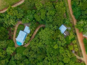 Aerial view of rainforest home with pool and guesthouse in Dominical.