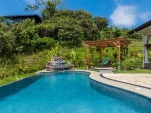 Beautiful infinity pool with garden and outdoor seating in Dominical, Costa Rica.