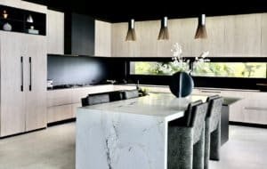 Contemporary kitchen with marble island, sleek cabinetry, and pendant lighting.