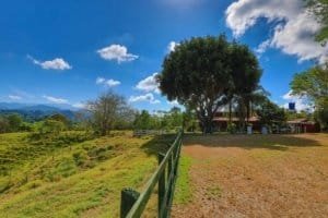 Scenic view of hacienda style home, stables, and horse corral in Dominical.