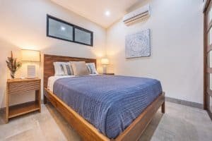 Modern bedroom with wooden furniture, air conditioning, and rainforest decor.