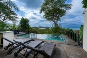 Ocean view villa with pool, lounge chairs, and lush tropical scenery in Dominical.