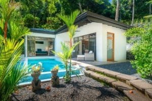Modern Costa Rican home with pool, surrounded by lush greenery and tropical plants.