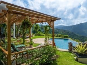 Beautiful outdoor living area with pool, garden, and mountain views in Costa Rica.