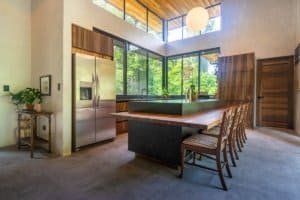 Contemporary kitchen with large windows overlooking lush jungle in Dominical.