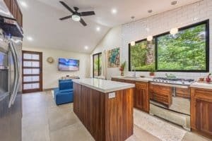 Modern kitchen with large windows overlooking lush rainforest in Dominical.