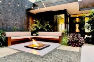 Modern outdoor lounge with fire pit and lush tropical plants in Costa Rica.