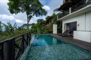 Luxury villa with infinity pool, lush greenery, and ocean view in Dominical.