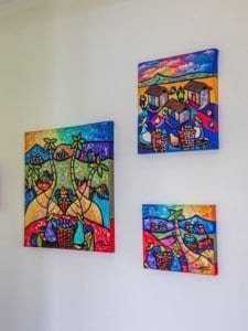 Vibrant local artwork displayed on a white wall in Dominical, Costa Rica.