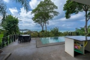 Scenic ocean view from villa with pool, surrounded by lush greenery in Dominical.