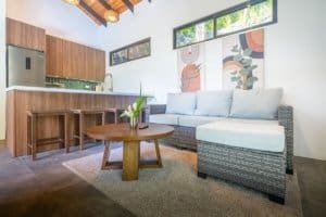 Bright living room with white sofa, wooden coffee table, and colorful wall art.