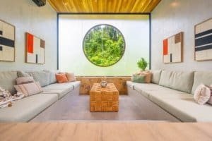 Modern living room with large circular window and jungle view in Dominical.