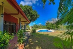 Beautiful backyard with pool, lush greenery, and tropical plants in Dominical.