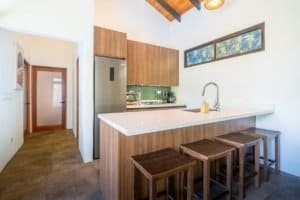 Contemporary kitchen with ocean view, wooden cabinets, and breakfast bar.