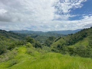 Scenic view of lush green mountains and cloudy sky in Dominical, Costa Rica.
