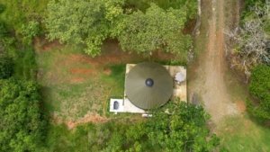 Aerial view of a property in Dominical, Costa Rica with lush greenery and a circular structure.