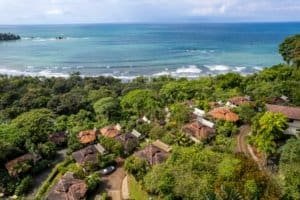 Aerial view of oceanfront villa with pool and lush greenery in Dominical, Costa Rica.