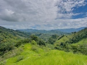 Lush green hills and mountains in Dominical, Costa Rica under cloudy sky.