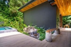 Modern Japanese-style home with pool surrounded by lush jungle greenery.