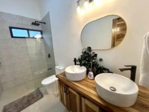 Contemporary bathroom with dual vessel sinks and walk-in shower in Costa Rica.