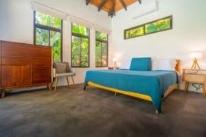 Bright bedroom with large windows, ocean view, and modern decor in Dominical.