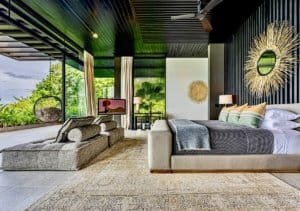 Modern bedroom with ocean view, stylish decor, and tropical surroundings.