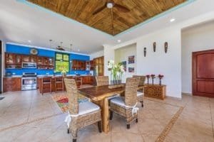 Open-concept kitchen and dining space with vibrant blue wall and wooden accents.