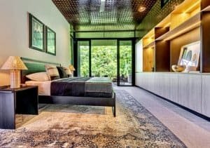 Modern bedroom with large glass doors overlooking lush greenery in Dominical.
