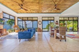 Spacious living room with ocean view, wicker furniture, and tropical decor.