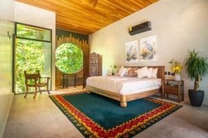 Japanese style bedroom with large window and jungle view, pool, and tropical decor.