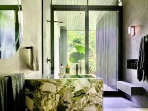 Modern bathroom with view of lush greenery and ocean in Dominical, Costa Rica.