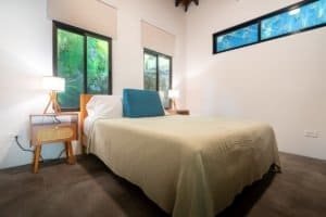 Bright bedroom with large windows, minimalist design, and natural light.