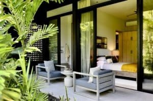 Modern bedroom with glass doors opening to lush tropical garden in Dominical.