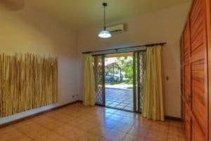 Bright living room with sliding glass door, yellow curtains, and wooden closet.