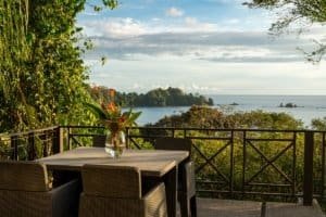 Balcony view of ocean, lush greenery, and distant islands from Dominical villa.