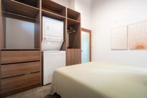 Bedroom with built-in wooden storage and laundry area in Dominical.